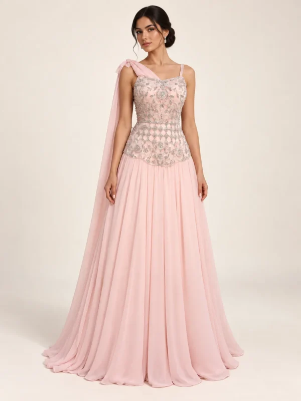 Blush embellished gown with slender straps, flowing skirt and shoulder drape